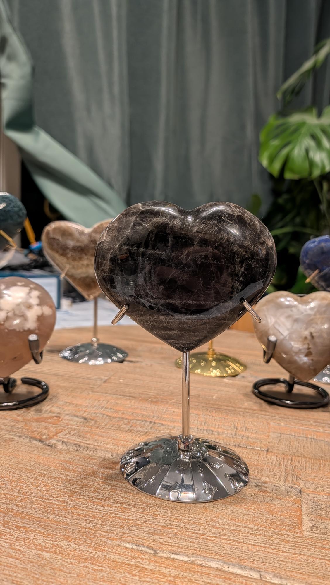 "Close-up van een zwart maansteen hart van 207 gram met zichtbare natuurlijke lijnen en kristalstructuur, afmeting 7.5 x 8 cm."