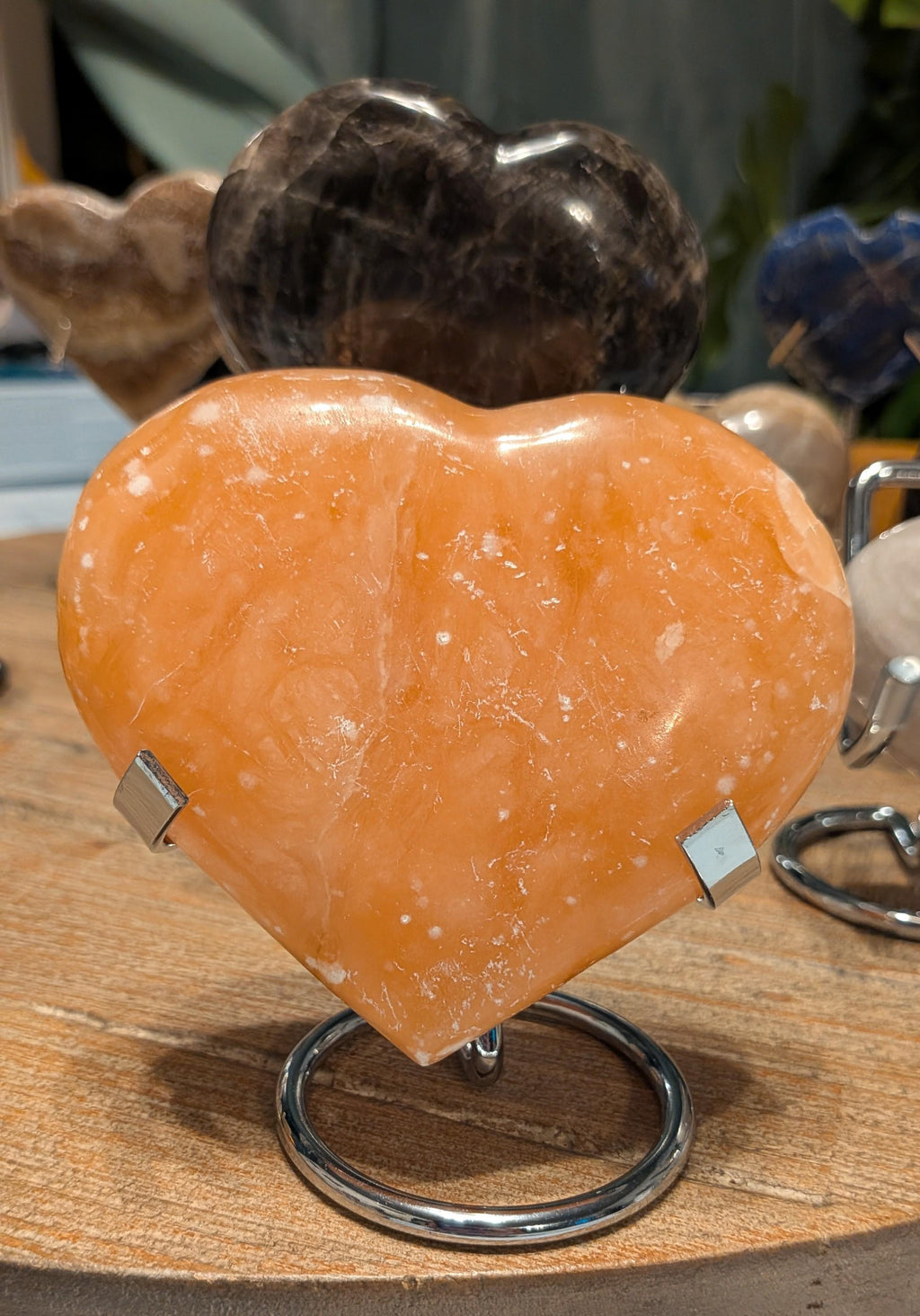 "Groot gepolijst oranje calciet hart van 308 gram op een zilverkleurige standaard, 10x10 cm, felle oranje kleur."