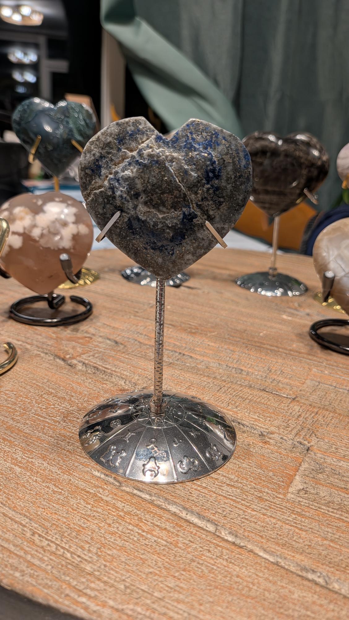 "Diepblauw Lapis Lazuli hart van 109 gram op een gedetailleerde zilverkleurige standaard met bewerkte voet."