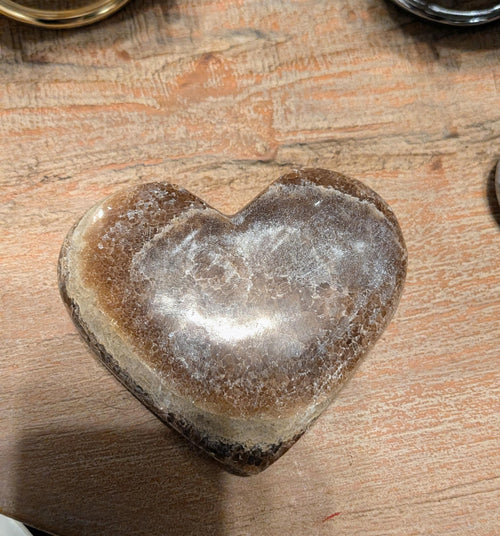 "Detail van de zijdeachtige glans en de unieke minerale banen van een natuurlijk onyx hart."