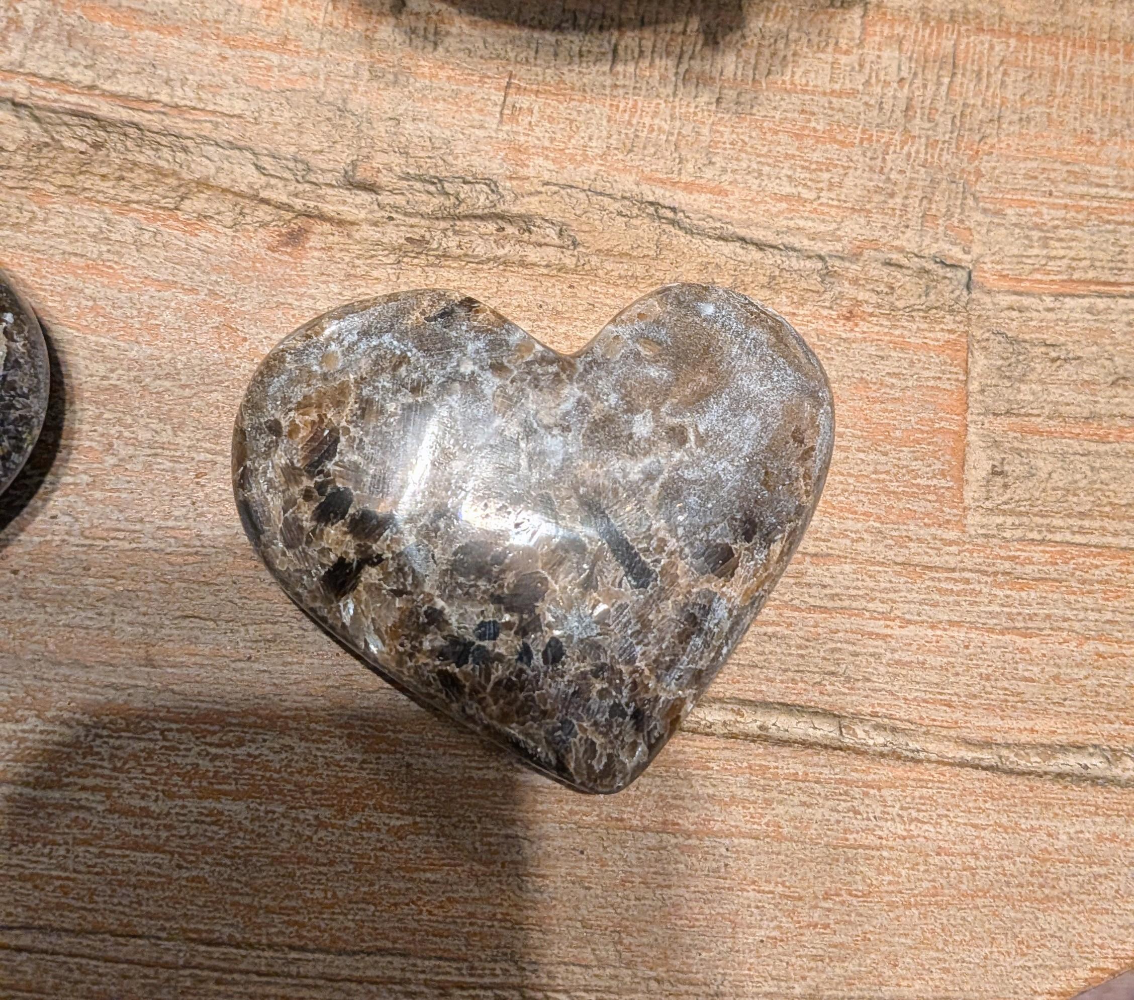 "Detail van de gepolijste glans en de gelaagde minerale structuur van een grijs-bruin onyx hart."