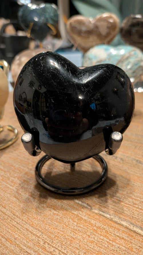 "Hoogglans gepolijst Zwarte Onyx hart van 289 gram op een zilverkleurige standaard."