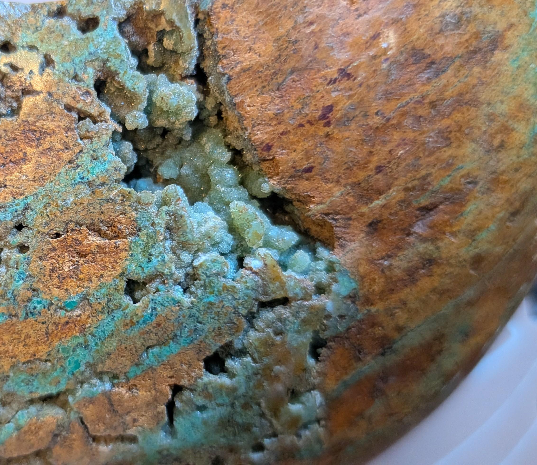 Close Up Handgeslepen Oceaan Jaspis halve maan van 242 gram met een uniek patroon van aardse bruintinten en groene ronde orbicles, verticaal gefotografeerd op een witte textiele ondergrond.