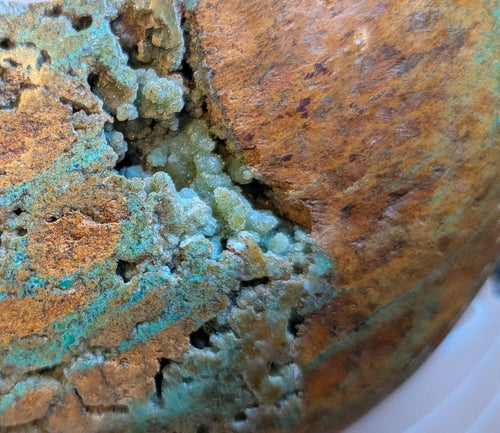 Close Up Handgeslepen Oceaan Jaspis halve maan van 242 gram met een uniek patroon van aardse bruintinten en groene ronde orbicles, verticaal gefotografeerd op een witte textiele ondergrond.