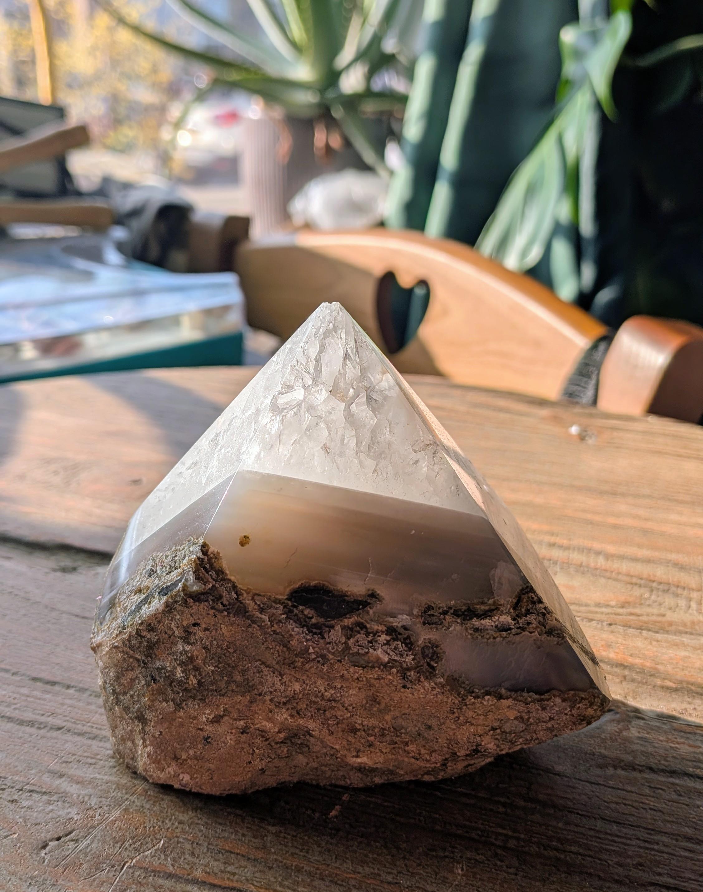 Een grote, handgepolijste Braziliaanse Agaat freeform van 622 gram met natuurlijke witte, bruine en grijze gelaagde patronen, gefotografeerd tegen een natuurlijke achtergrond.