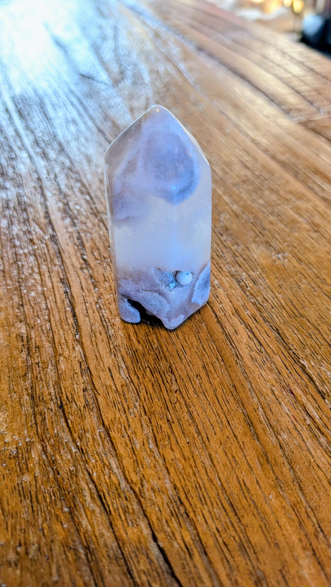 "Vooraanzicht van een kleine bloem agaat toren van 6 cm met een zichtbare druzy holte aan de basis."