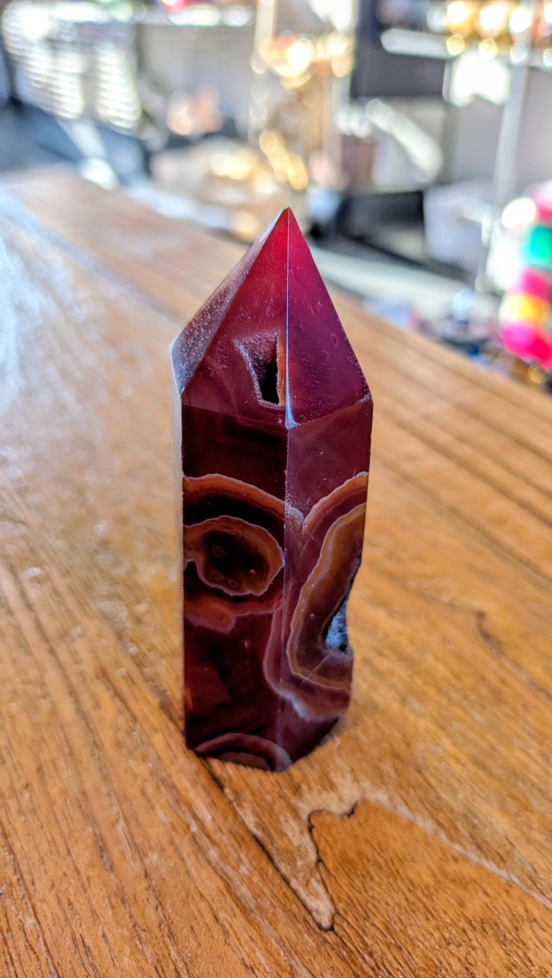 "Vooraanzicht van een 24,95 euro carneool toren met een kleine kristalholte en prachtige kleurbanden."