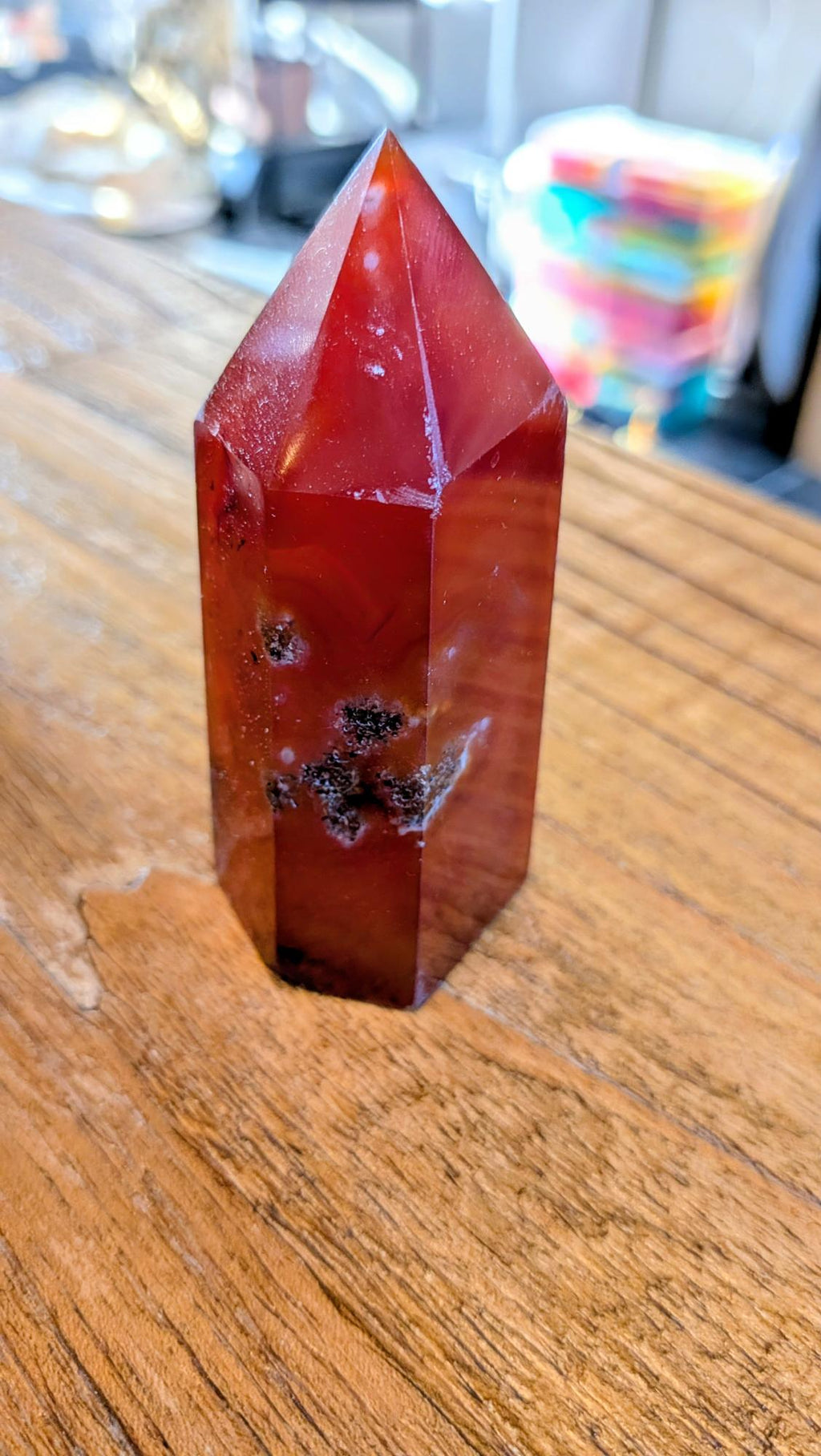 "Zijaanzicht van een 176 gram zware carneool punt die de diepe rode kleurlagen en glans laat zien."