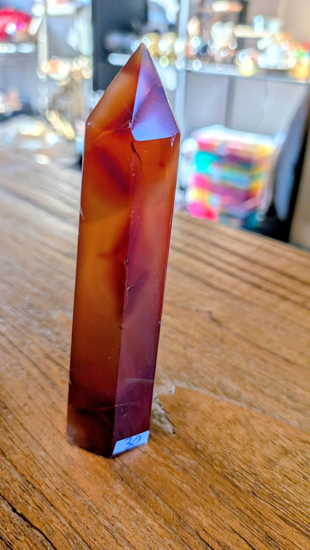 Slanke, 12 cm hoge carneool toren met een levendig kleurverloop van oranje naar dieprood."