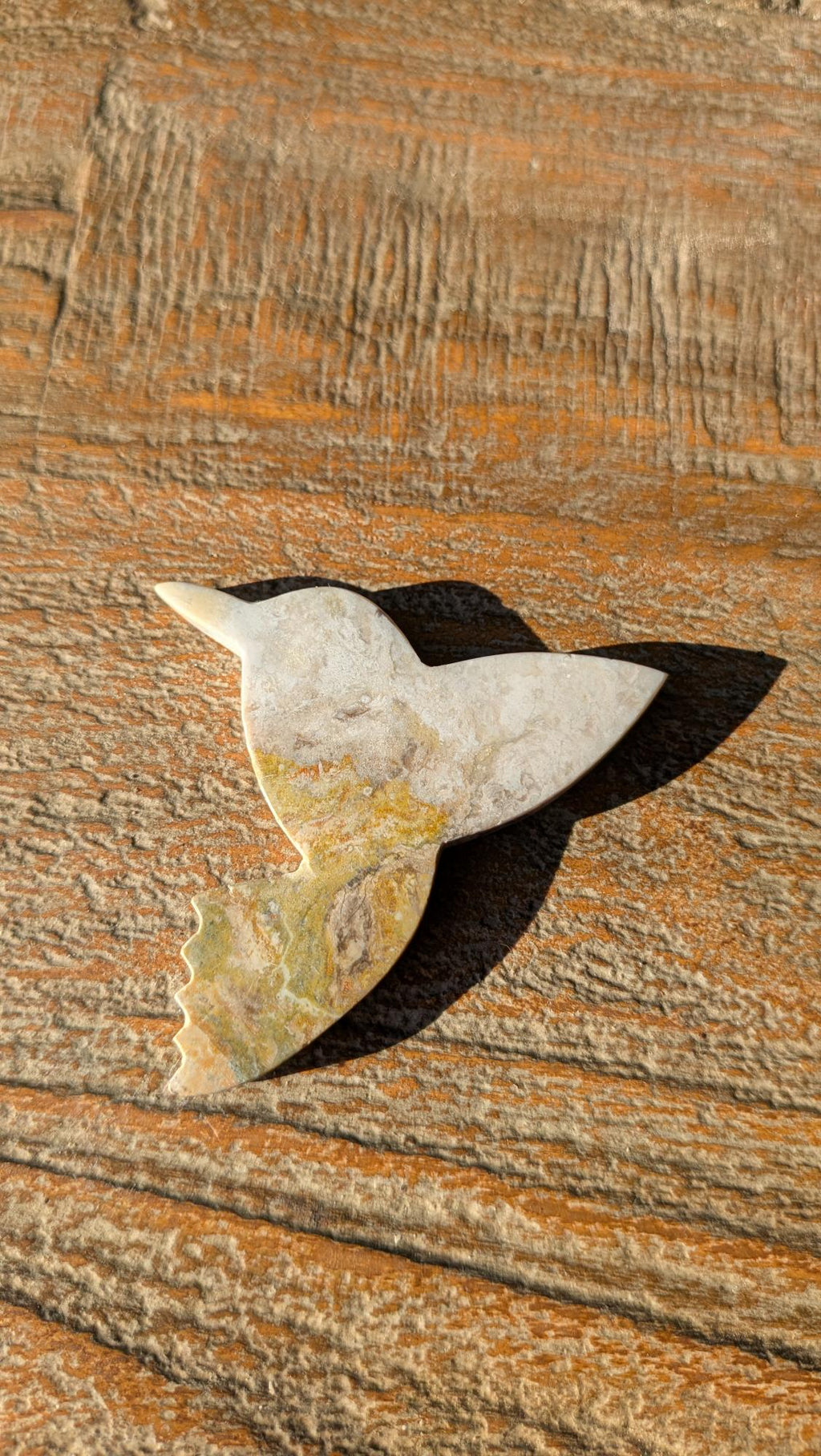 Detailopname van de vleugels en natuurlijke vulkanische patronen van de handgemaakte Bumblebee Jaspis vogel uit Indonesië.