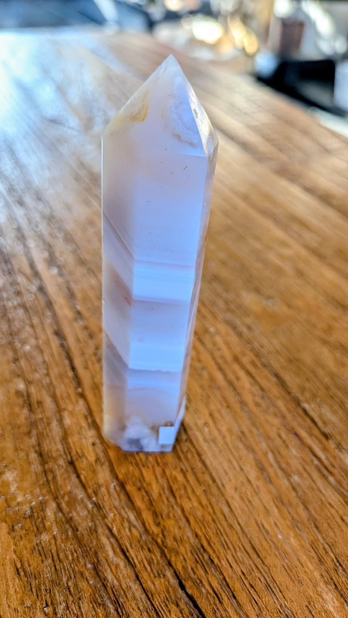 Zijaanzicht van de Flower Agate punt, vertoont de natuurlijke gelaagdheid en kristalstructuur.