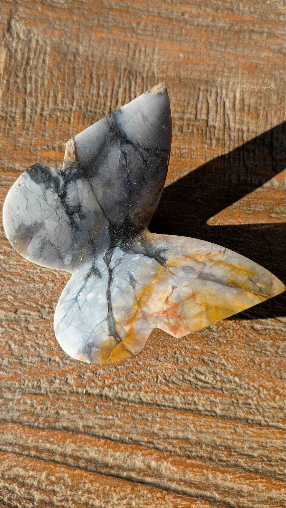 Handgesneden 3D-vlinder van grijsblauwe Chalcedoon met unieke donkere lijnen, authentiek vakmanschap uit Java, Indonesië.