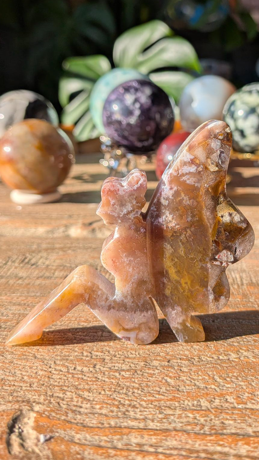 Detail van de achterzijde van het Pluimagaat elfje, tonend de natuurlijke witte pluimen en doorschijnende kristalstructuur.