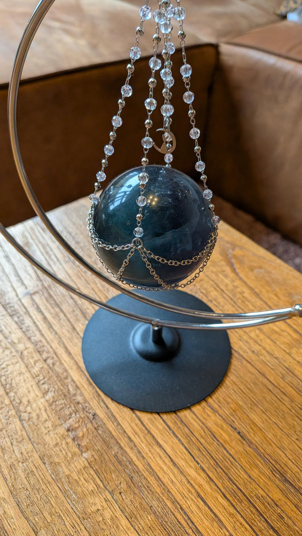 "Grote groene fluoriet bol van 8 cm zwevend in een zilveren kettingharnas aan een maanvormige standaard, statement edelsteen decoratie."