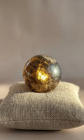 Heldere bruine Rookkwarts bol van 3,5 cm op een beige ondergrond. Kristal voor bescherming en het afvoeren van negatieve energie.