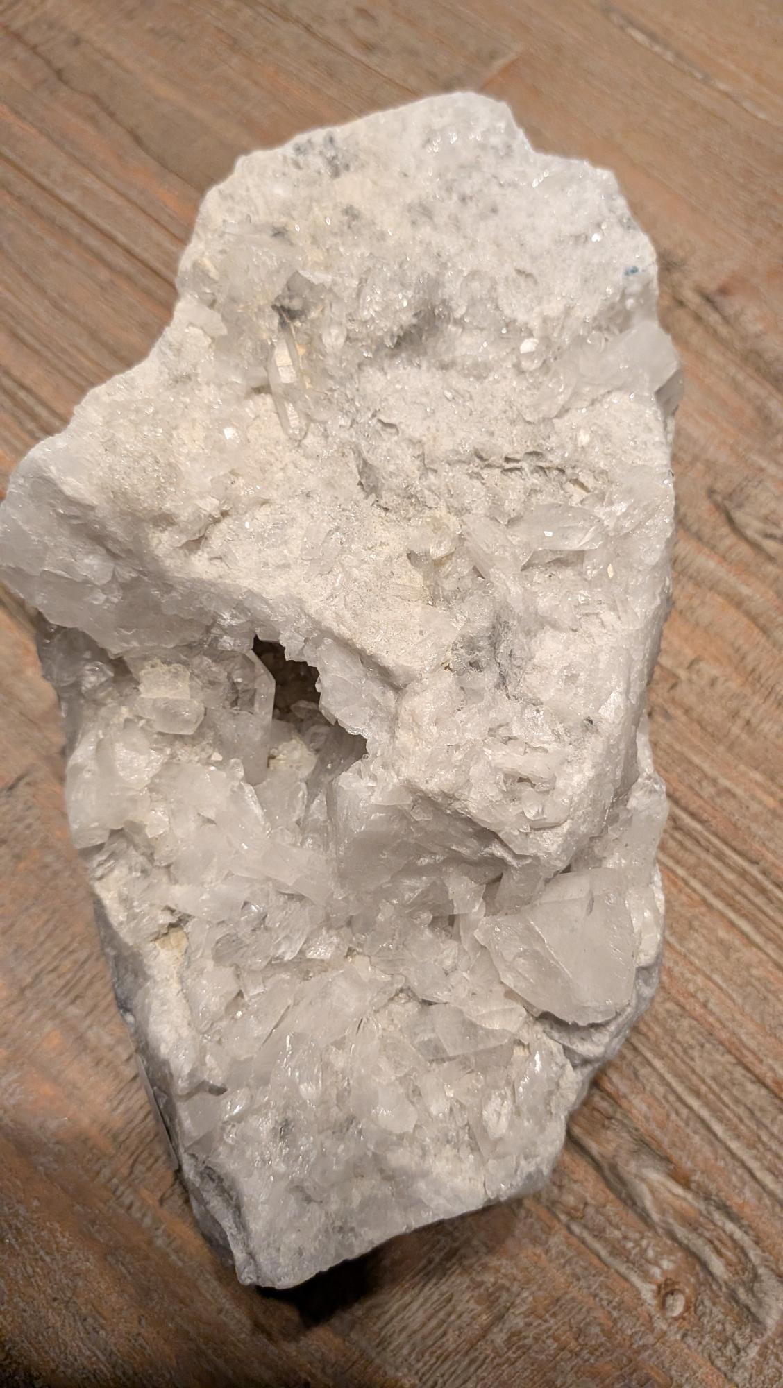 Groot wit Bergkristal cluster met een natuurlijke holte waarin een heldere, transparante kristalpunt zichtbaar is.