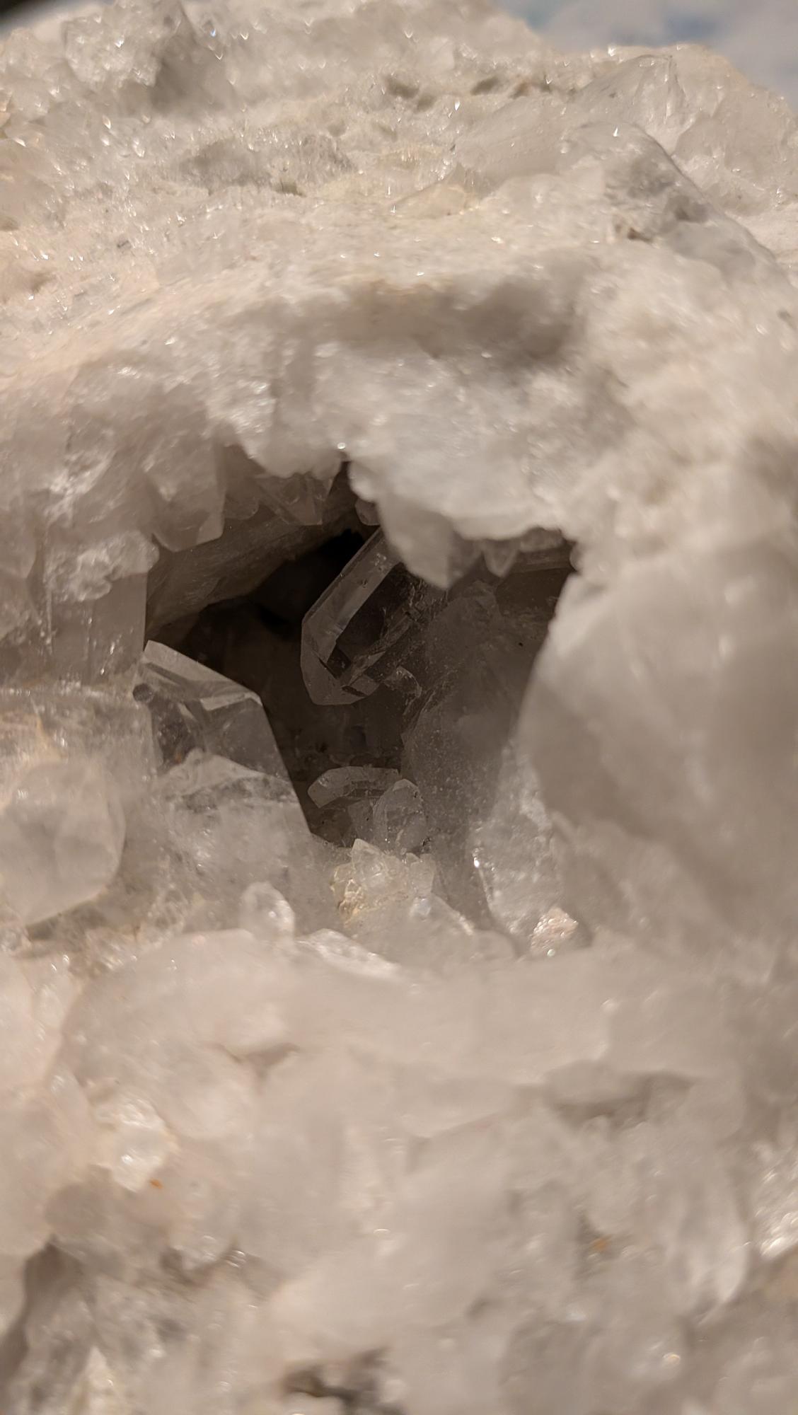 Groot wit Bergkristal cluster met een natuurlijke holte waarin een heldere, transparante kristalpunt zichtbaar is.