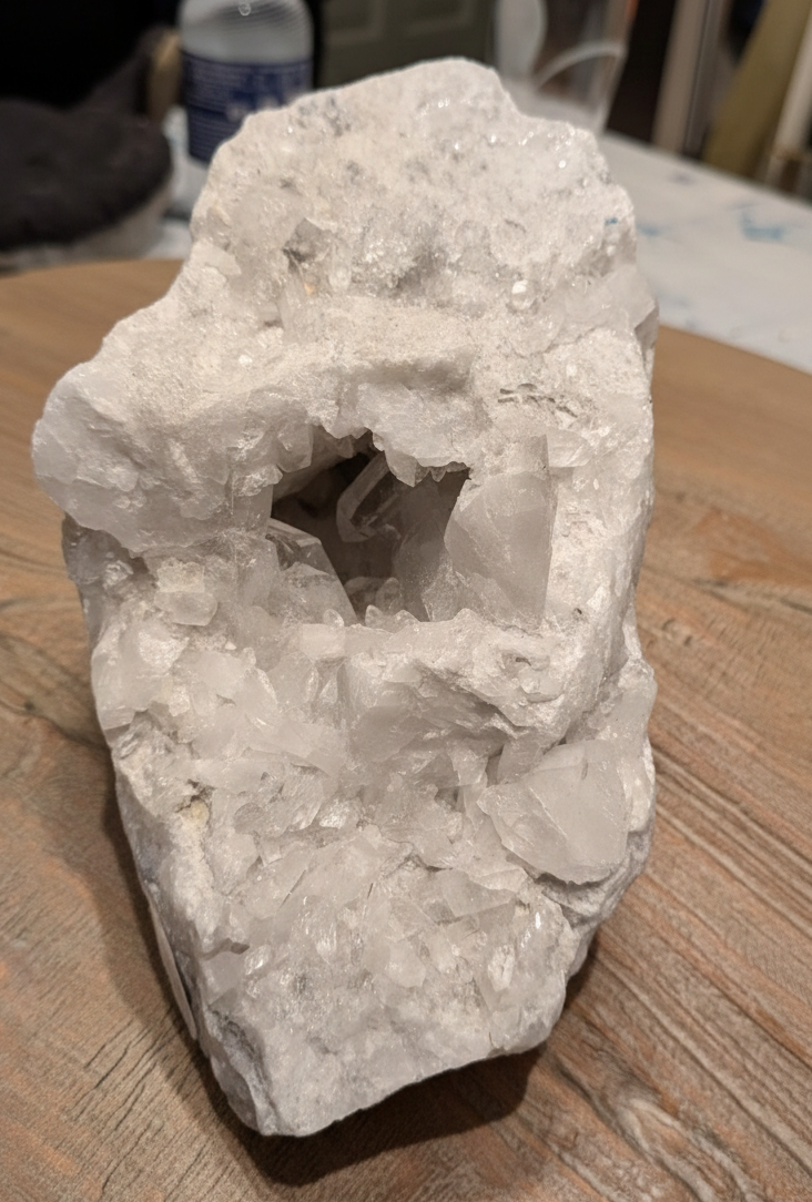 Groot wit Bergkristal cluster met een natuurlijke holte waarin een heldere, transparante kristalpunt zichtbaar is.