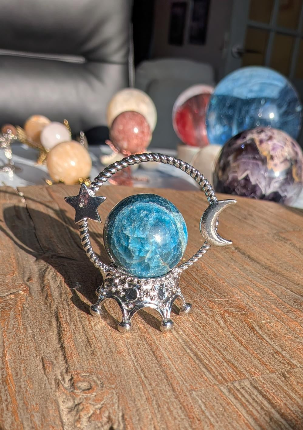 Kleine diepblauwe Apatiet bol van 3,5 cm diameter en 83 gram in een zilverkleurige standaard met een ster en maan symbool