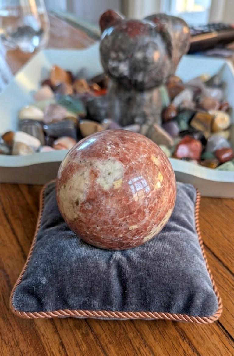 Grote gepolijste oranje Zonnesteen bol van 6 cm met natuurlijke glinsteringen, prijs 39,95 euro. Houders apart verkrijgbaar.