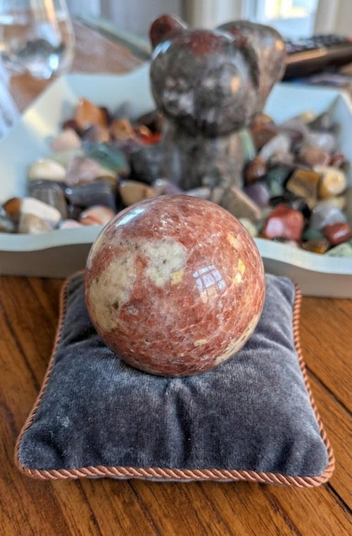 Grote gepolijste oranje Zonnesteen bol van 6 cm met natuurlijke glinsteringen, prijs 39,95 euro. Houders apart verkrijgbaar.