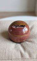 Grote gepolijste Polychroom Jaspis bol van 6 cm met warme aardetinten en een natuurlijke druzy holte, prijs 32,50 euro. Houders apart verkrijgbaar.