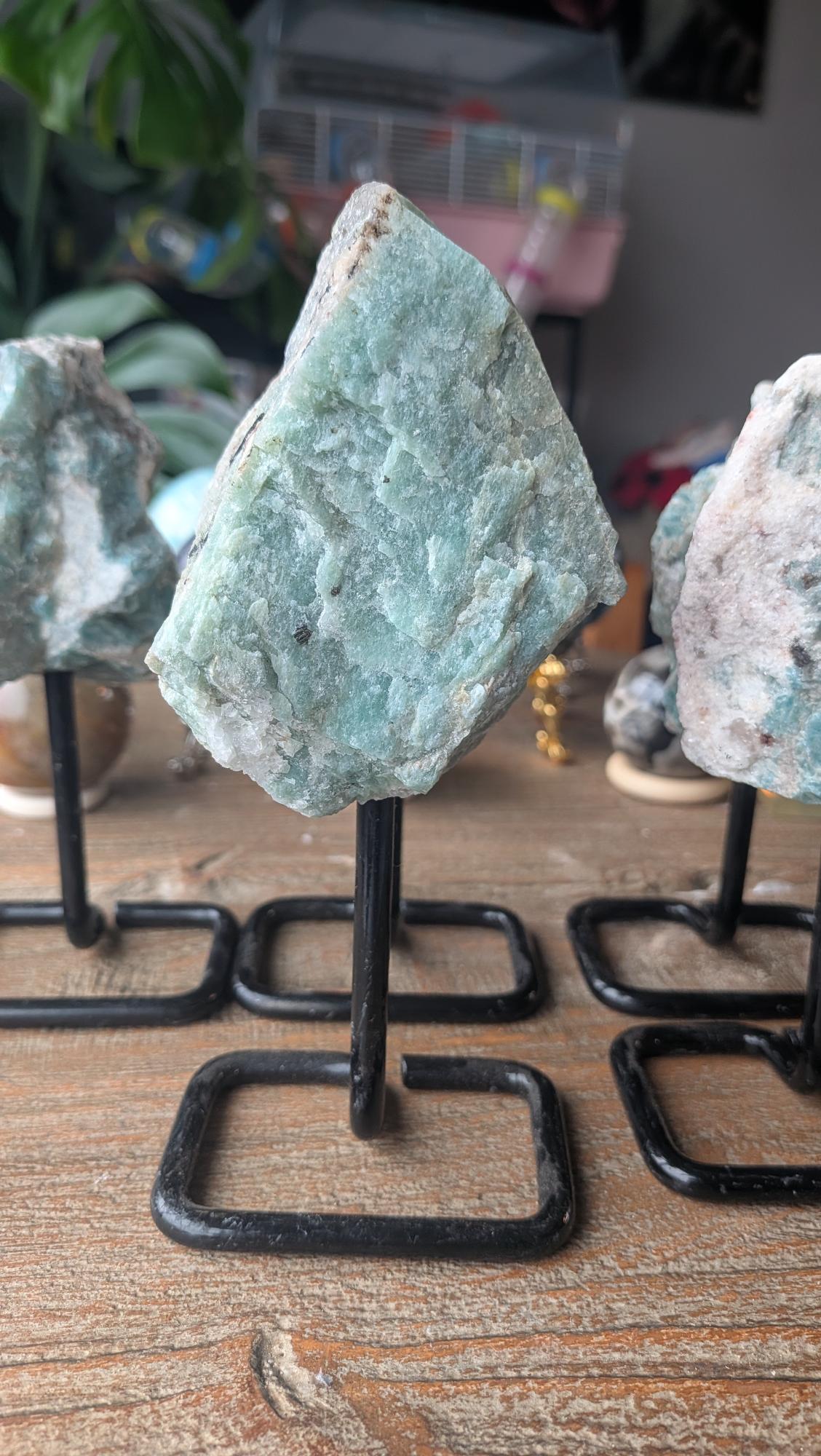 Slank en hoog exemplaar ruwe Amazoniet op een zwarte standaard, item #211, met een gewicht van 333 gram en 16 cm hoogte.