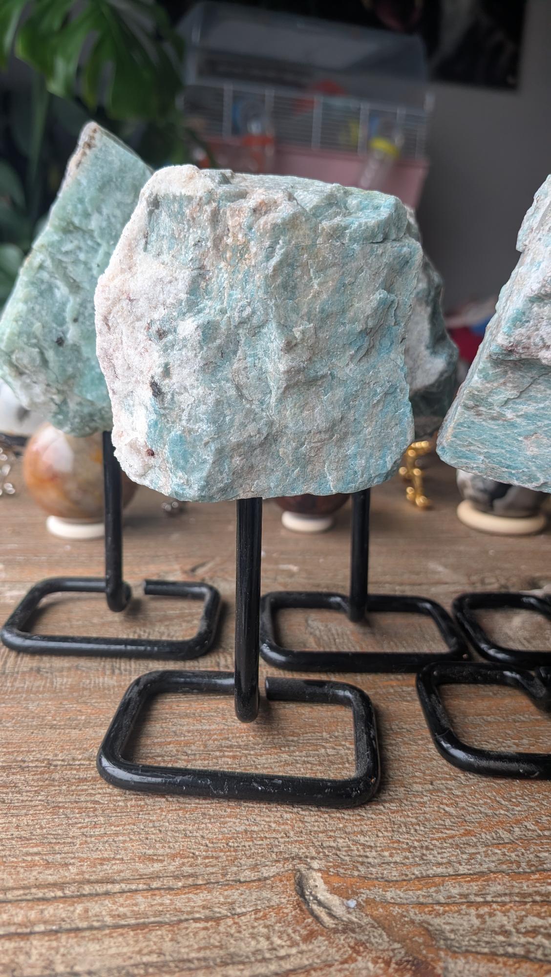 Unieke ruwe Amazoniet edelsteen van 332 gram op zwarte standaard, 14 cm hoog.