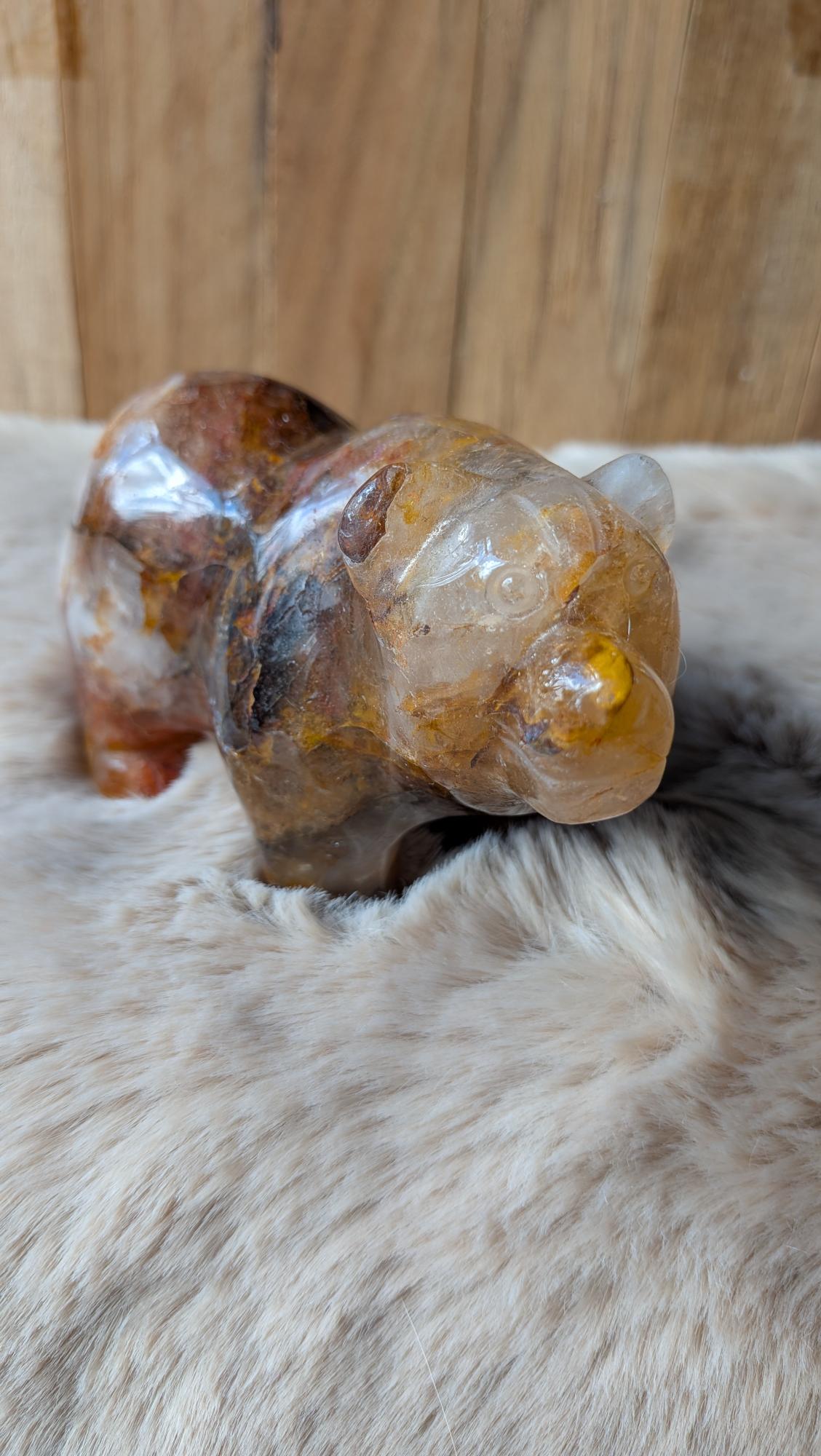 Vooraanzicht van een zware fire kwarts beer van 509 gram op een houten ondergrond.