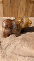 Gedetailleerde handgesneden beren carving van fire kwarts met warme vlamtekeningen.