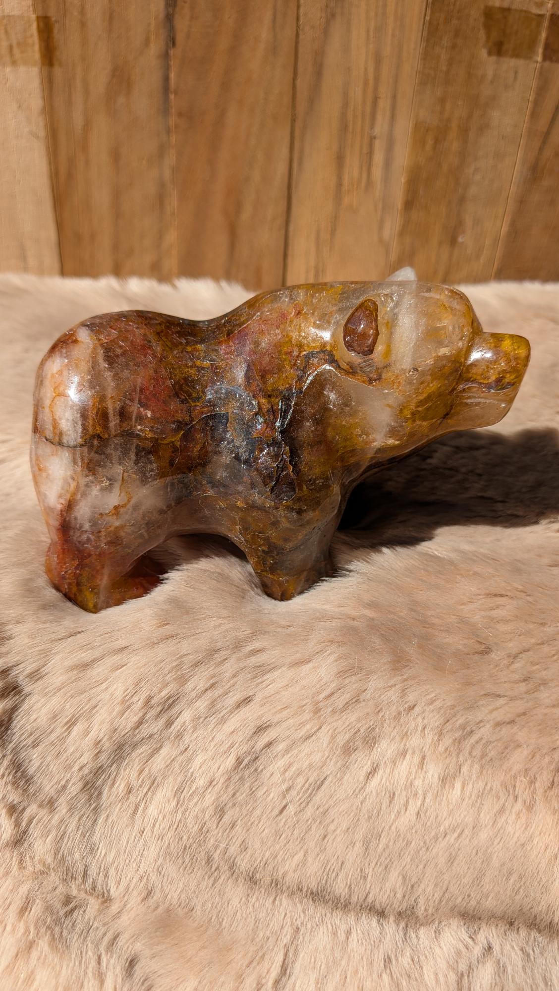 Gedetailleerde handgesneden beren carving van fire kwarts met warme vlamtekeningen.