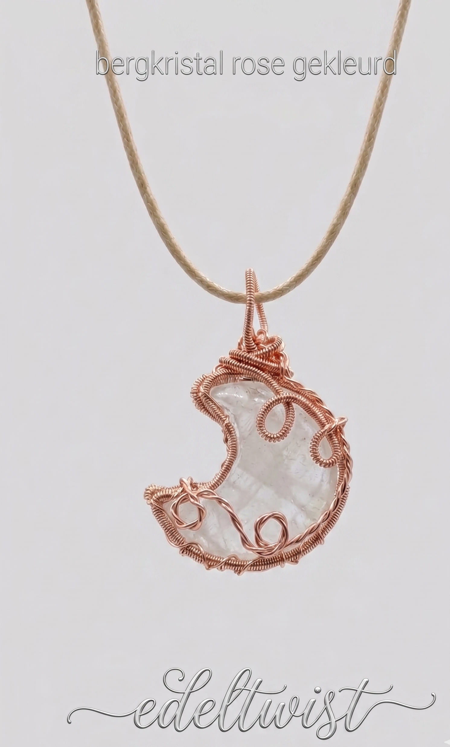 Een handgemaakte bergkristal maan-ketting, vakkundig gewrapt in glanzend rose-kleurig draad door Edeltwist. De hanger hangt aan een dunne, beige cord-ketting op een neutrale, lichtgrijze achtergrond. Bovenaan staat de tekst "bergkristal rose gekleurd" en onderaan het sierlijke logo "edeltwist".