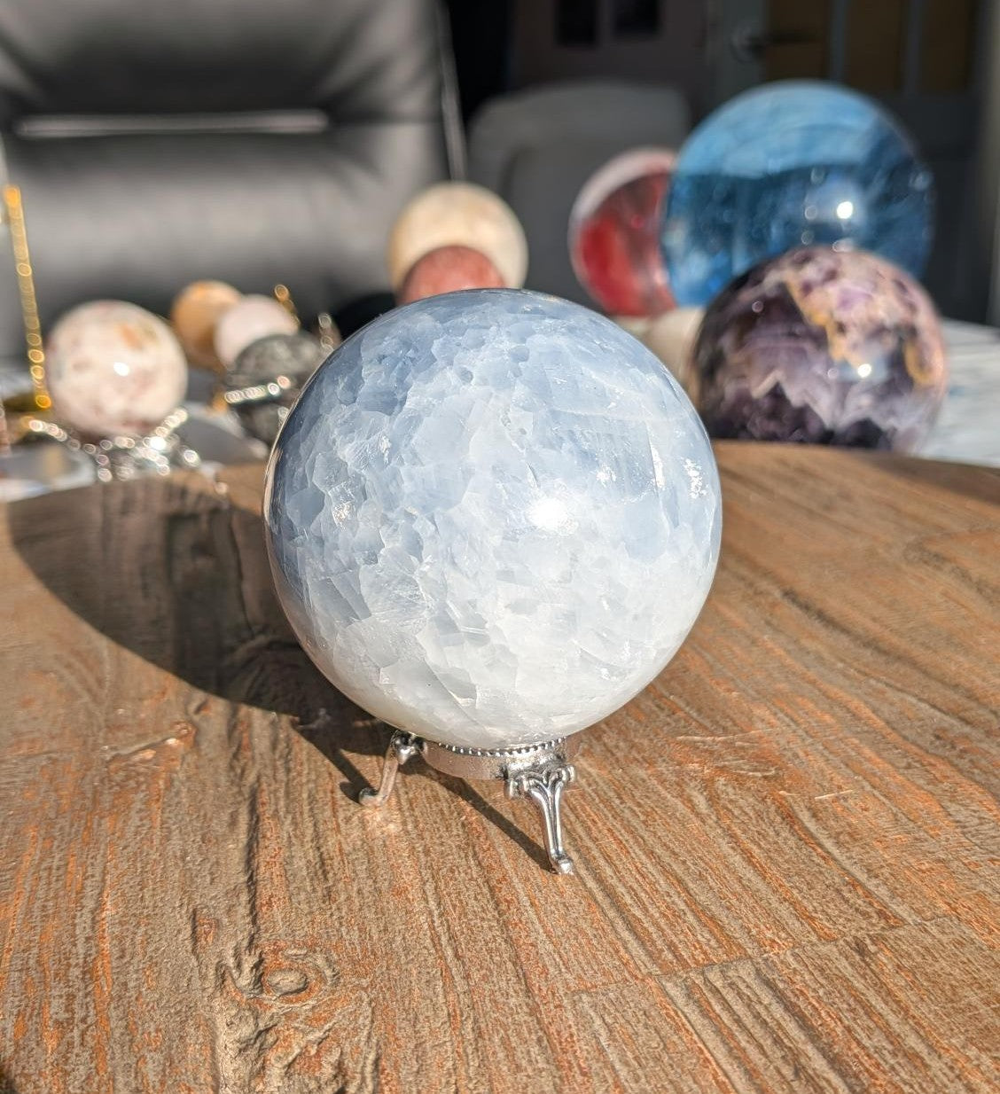 Lichtblauwe natuurlijke Blauwe Calciet bol van 7 cm diameter en 504 gram op een sierlijke zilverkleurige driepoot standaard