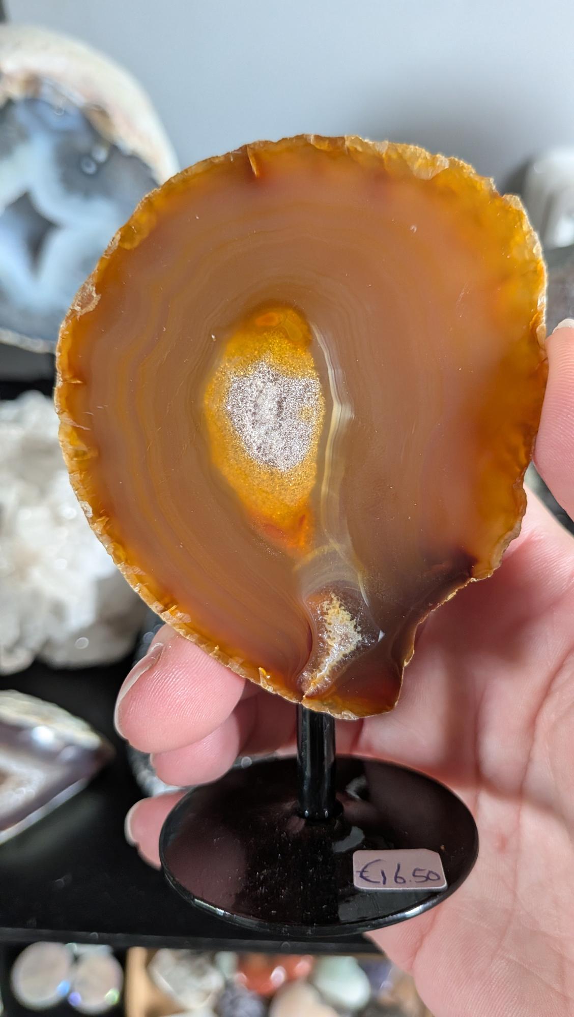 Bloedcarneool, carneool, edelsteen interieur, edelwist, kristal decoratie, uniek mineraal, verzamelobject, warme tinten, natuurlijke woonaccessoires, geode op standaard.