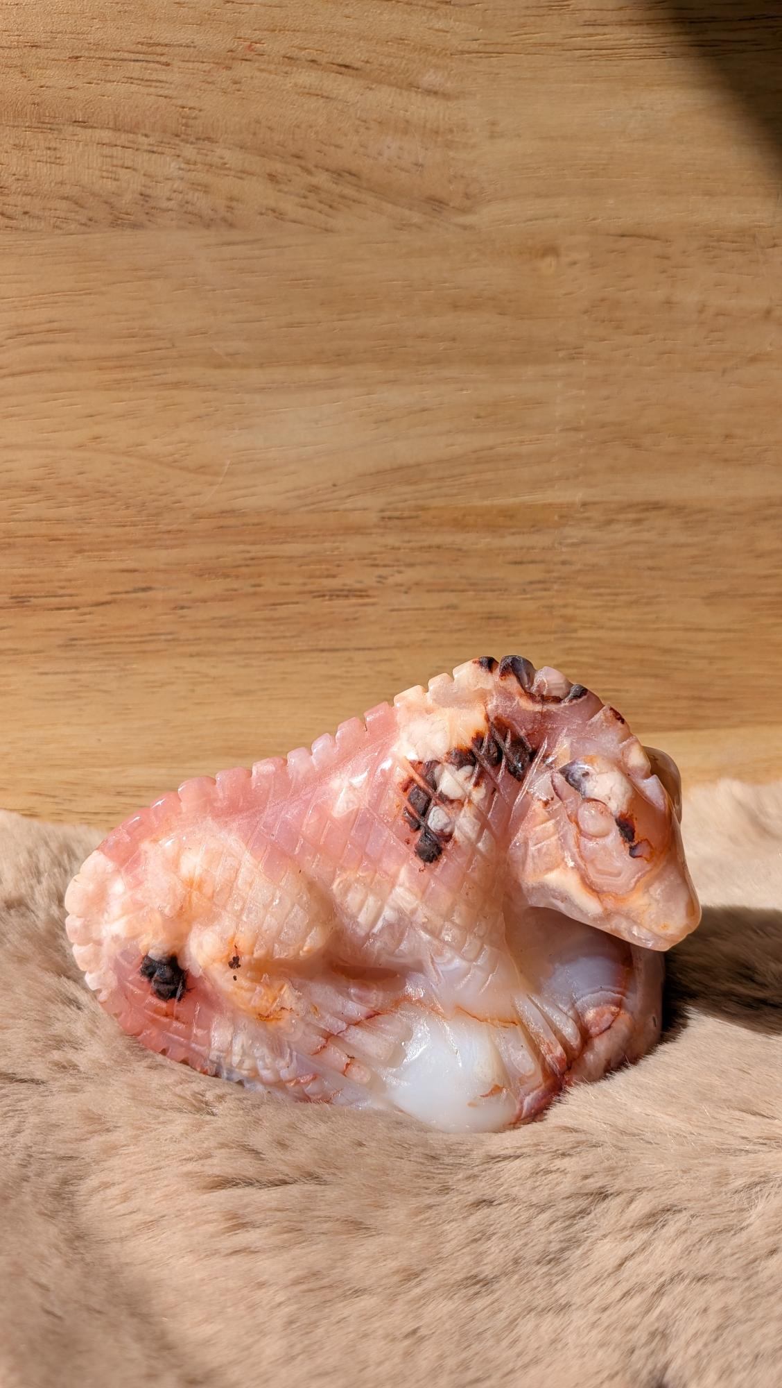 Handgesneden hagedis carving van carneool bloemagaat met fijne schubbenstructuur.