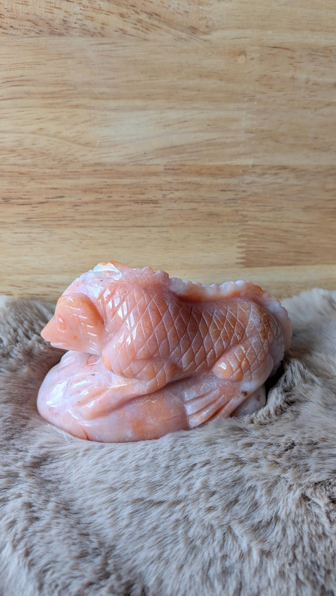 Detailopname van de fijne carving en de natuurlijke steenstructuur van de carneool bloemagaat hagedis.