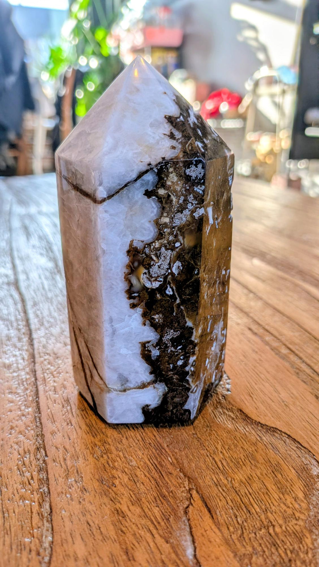 "Gepolijste Oceaan Jaspis tower uit Madagaskar met wit-bruine organische patronen, staand op een houten ondergrond."