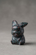 Handgeslepen edelsteen figuurtje van een zittende Pokémon (Pikachu), vervaardigd uit Cinnabar Jaspis met een donkergroene basis en opvallende rode vlekken.