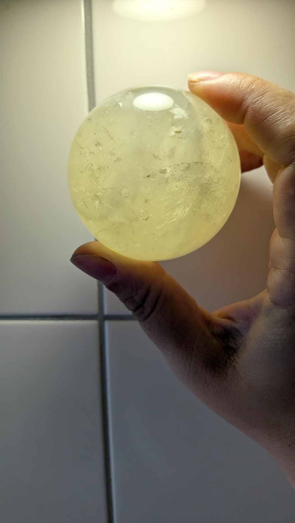 Gepolijste citrien bol van 56 mm met interne regenboogjes, bekend om zijn positieve werking en vreugdevolle energie.