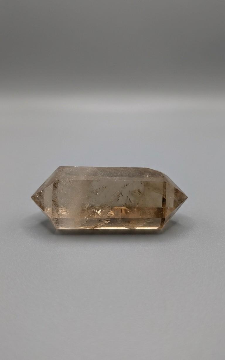 Donkere citrien dubbeleinder kristal van 48 mm met diepe kleurnuances, gefotografeerd op een neutrale achtergrond.