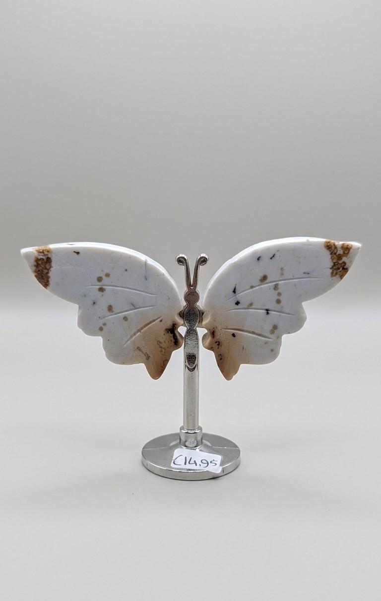 Witte edelsteen vlinder van Dendritische Opaal met zwarte en bruine vlekjes op een zilverkleurige standaard.