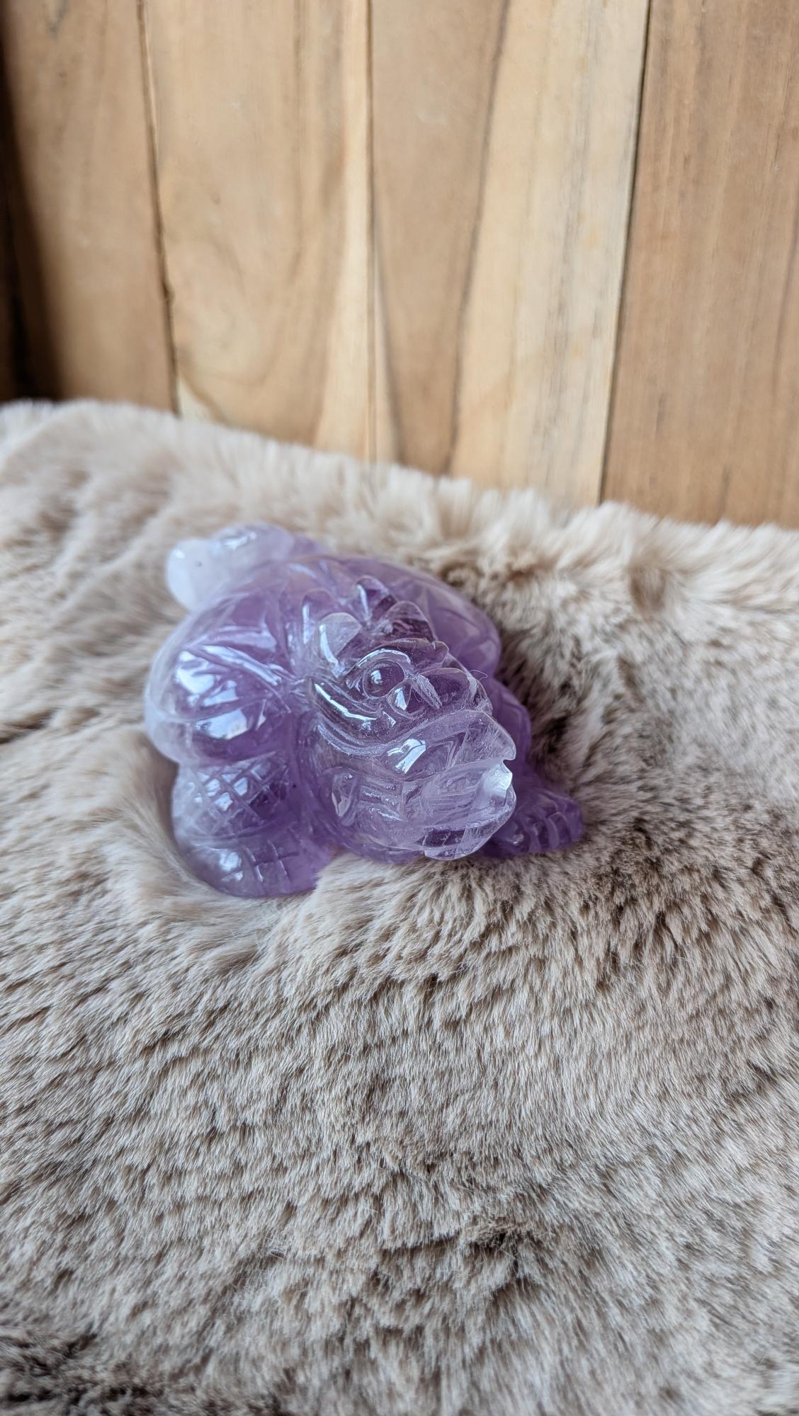 Vooraanzicht van een handgesneden amethist dragon turtle carving van 426 gram met gedetailleerd schild.
