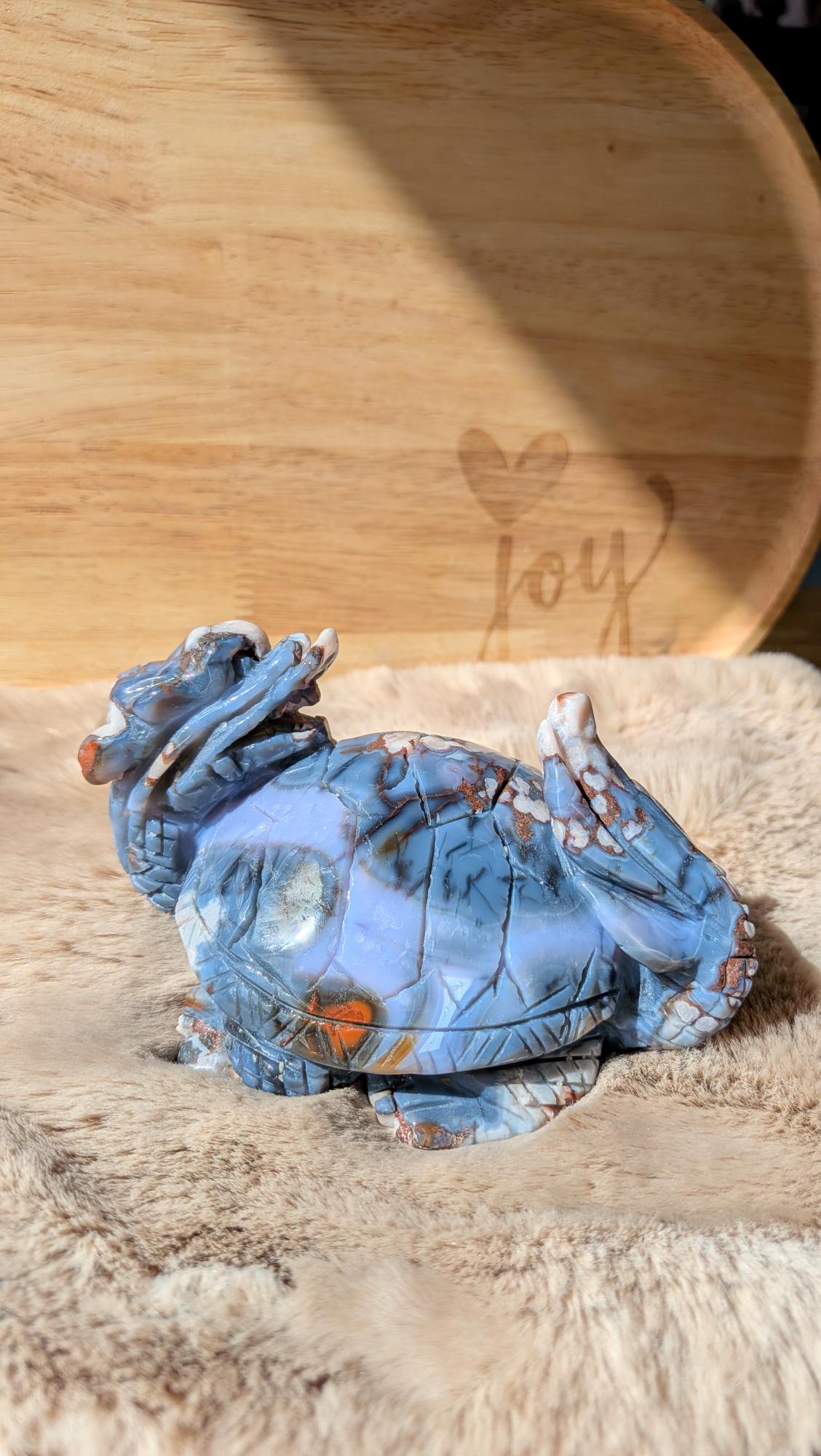 Detailopname van de fijne carving en kristalstructuur van de blauwe bloemagaat dragonturtle.