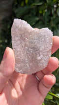 Een hand houdt een sprankelende suiker druzy chalcedoon van 39 gram vast, met een fijne, suikerachtige kristaltextuur