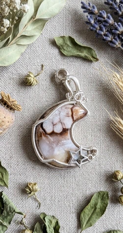 Detail van de natuurlijke bloem-insluitsels in de dubbelzijdige Bloemagaat maan hanger.