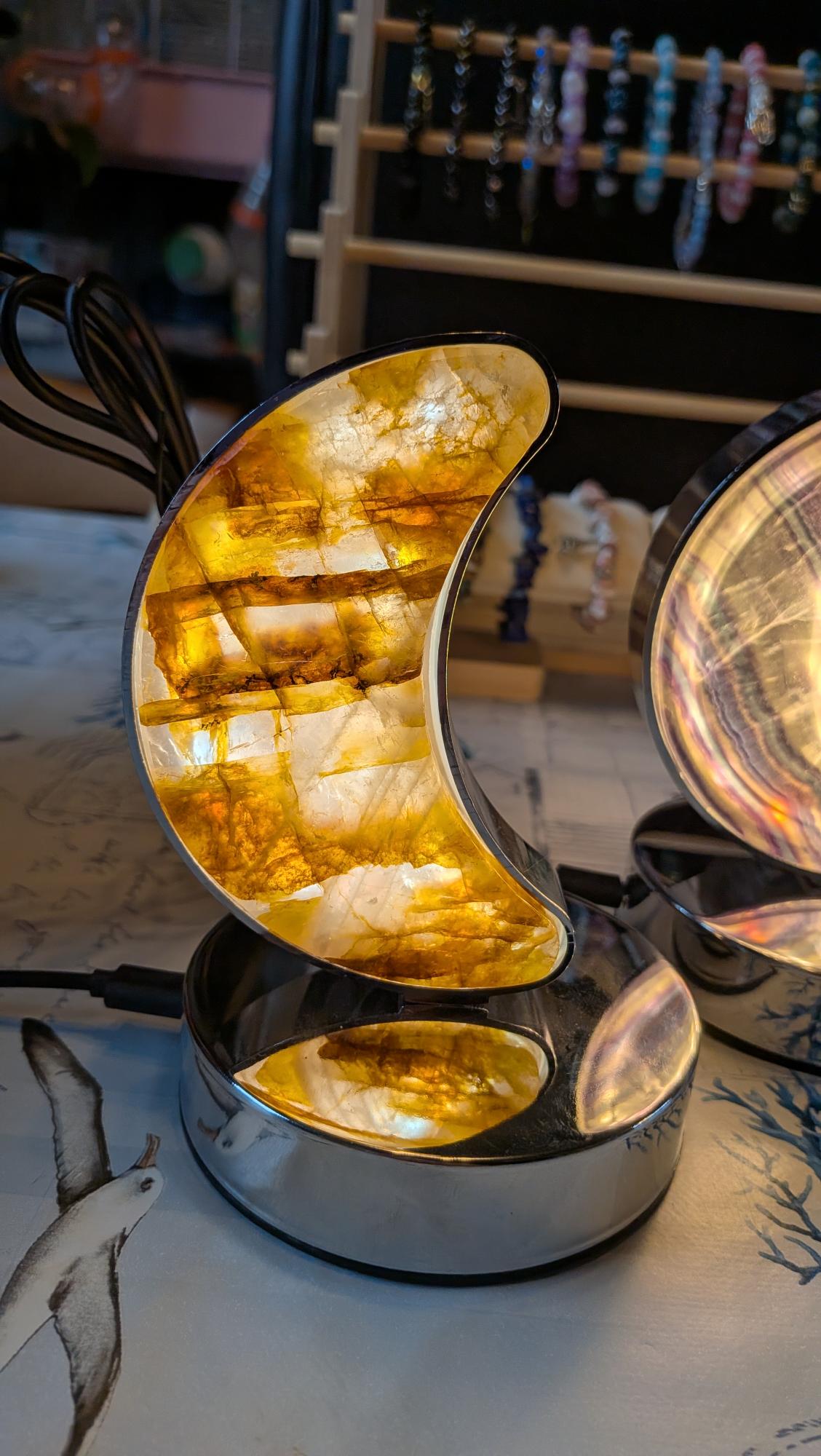 Fire Quartz maanlamp van echte natuursteen op een chromen voet met warm oranje licht.