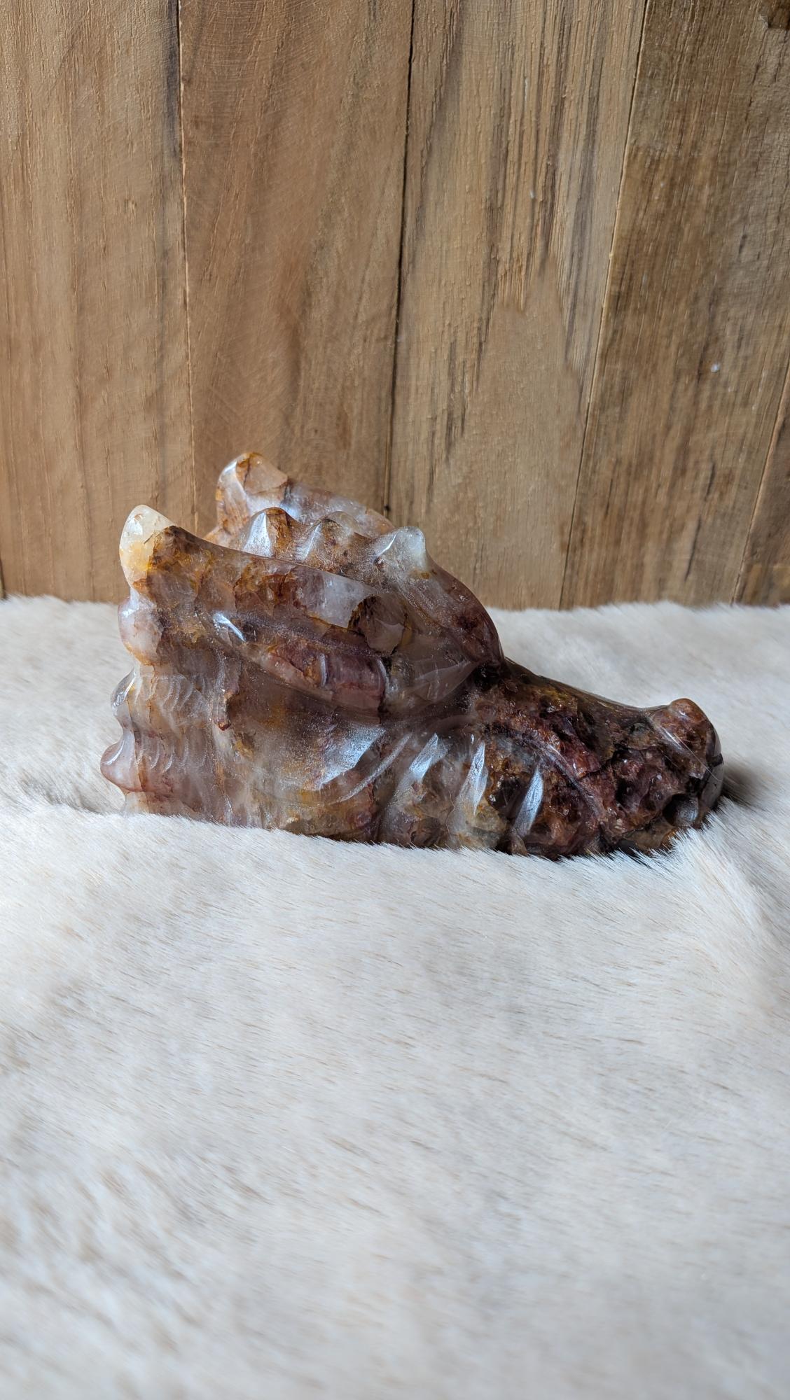 Detailopname van de unieke kristalstructuur en diepe rode tinten van de fire kwarts draak.