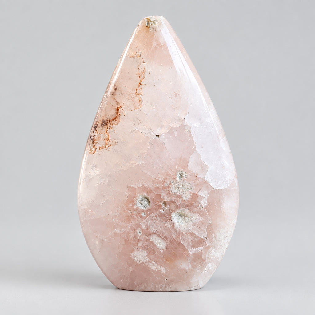 Slanke Bloemagaat punt met witte bloempatronen en roze tinten, 10,5 cm hoog en 190 gram, op een houten ondergrond.
