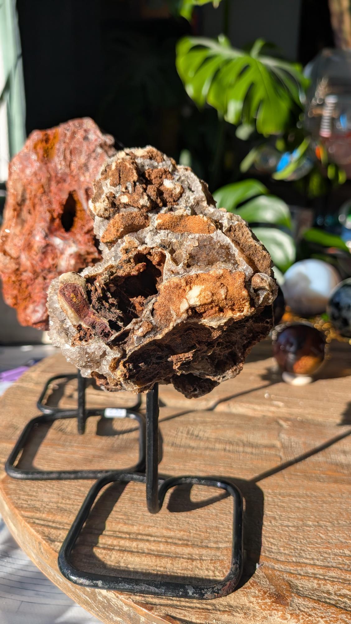 Achterzijde van de geode op standaard, tonend het ruwe okergele en bruine moedergesteente uit Brazilië.