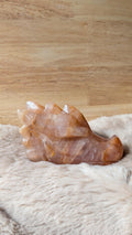 Gedetailleerde handgesneden draak carving van golden healer kwarts met warme gouden gloed.